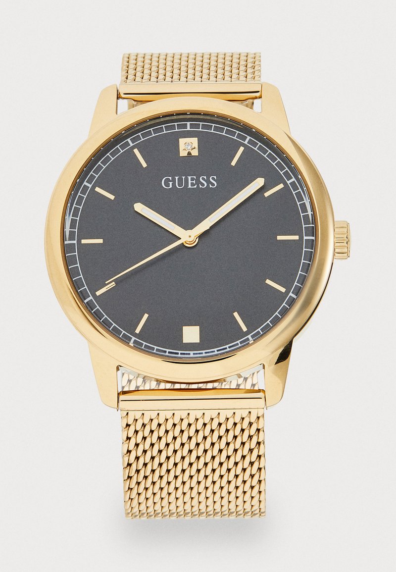 Gold mesh bracelet watch featuring a black dial, gold hour markers, simple hands, and a small square date window at 3 o'clock.