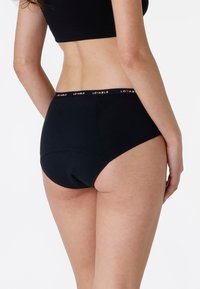 Slip di cotone nero con vita alta e logo rosso "Lovable" sulla cintura. Texture liscia, copertura totale sul retro e stile classico.