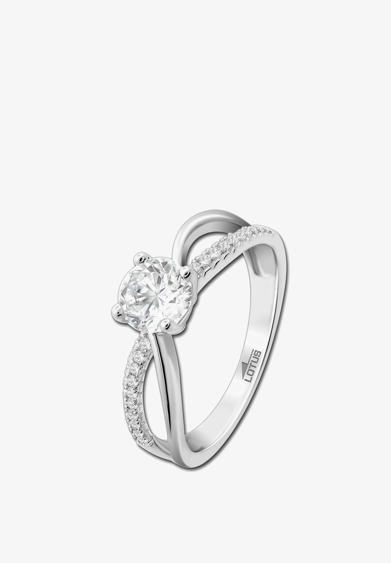 Silver ring featuring a large round cubic zirconia center stone, flanked by smaller stones on one side, with a smooth polished band.