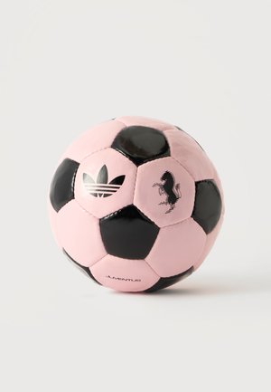 Balón de fútbol rosa y negro con logo de Adidas, emblema del caballo de Ferrari y texto Juventus sobre un fondo claro liso.