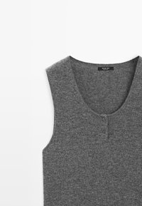 Pullover grigio senza maniche in morbido tessuto a maglia con scollatura rotonda e due dettaglio di bottoni nella parte frontale per la chiusura.