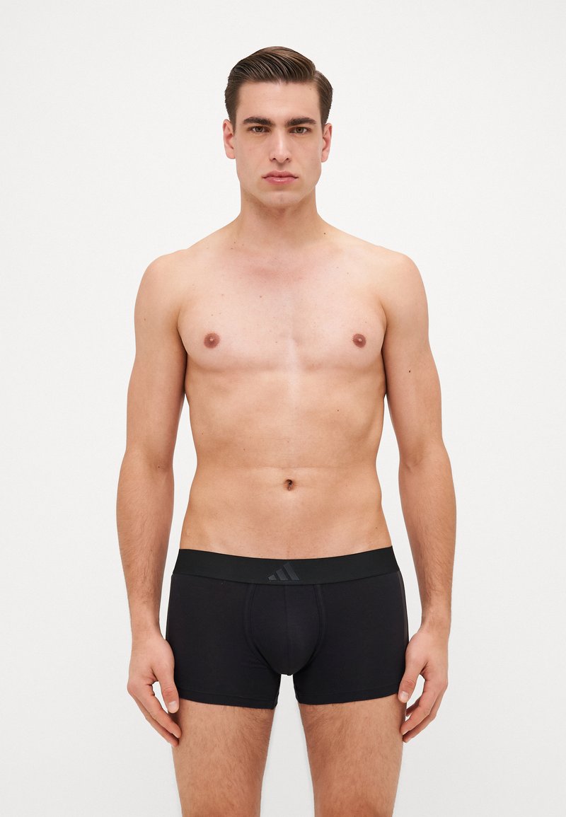 Schwarze Boxer-Shorts mit einem schwarzen Bund und einem dezenten Logo. Glattes Material, enganliegendes Design und Oberschenkellänge.