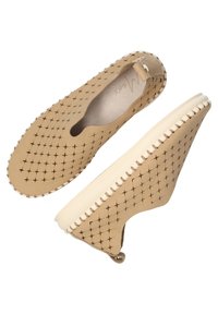 Beige instappers met een gepatternde bovenkant, met kleine kruisontwerpen, een gestructureerde afwerking en een contrasterende witte zool met stiksels.