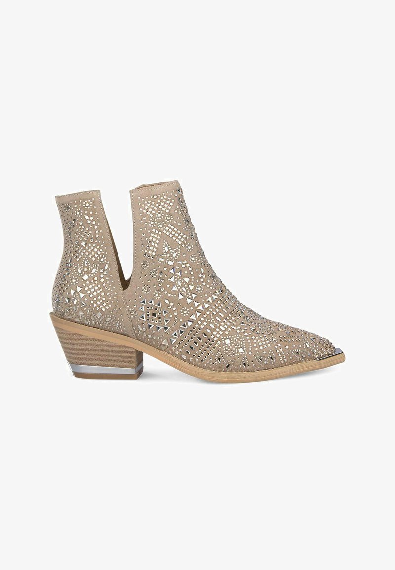 Bottines tan avec des motifs découpés et des accents de clous métalliques. Talon bas empilé avec une texture rayée contrastante. Design à bout pointu.