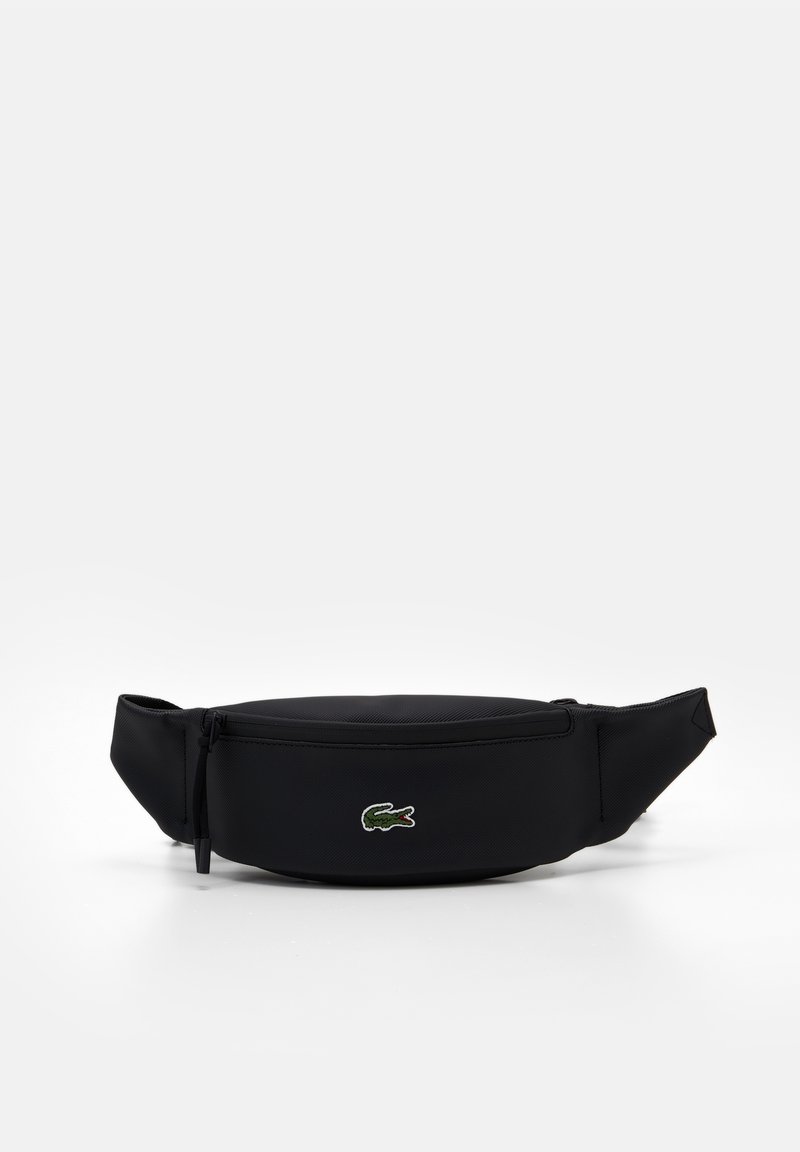 Sac banane noir zippé avec sangle ajustable et petit logo crocodile vert au centre devant.