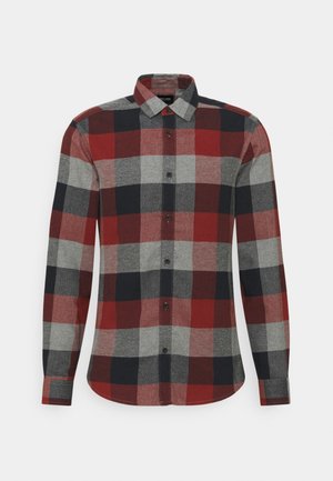 Chemise en flanelle à carreaux rouges, bleu marine et gris avec des manches longues, boutonnière et col. Présente un ourlet arrondi et un tissu texturé.