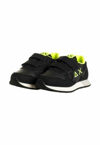 Scarpe sportive nere con due cinturini in Velcro, dettagli verde neon e suola bianca. Presentano una tomaia liscia e una suola testurizzata.