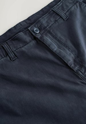 Modré bavlnené nohavice majú rovný strih, zapínanie na gombík a švy ako detail. Tkanina má hladkú štruktúru a mierne matný povrch.