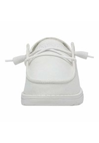 Sneaker bianca in tela con design piatto, punta rotonda e lacci bianchi. La suola è leggermente texturizzata e presenta un sottile bordo rialzato.