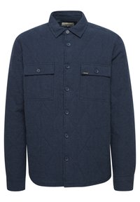 Navy quilted shirt jacket with a button-up front, two chest pockets, and subtle diagonal stitching pattern. Made from textured fabric.