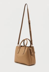 Skórzana torebka w kolorze tan, z dwiema górnymi rączkami, regulowanym paskiem na ramię, zamykaną kieszonką i zorganizowaną konstrukcją. Gładka tekstura, minimalne akcenty.