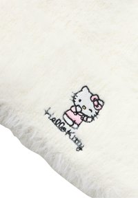 Vit fluffig tyg med en broderad Hello Kitty-design i rosa klädsel med svart kontur, tillsammans med texten "Hello Kitty."