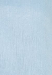 Světlomodrá látka s jemnou tkanou strukturou a subtilními variacemi v tloušťce nitě a vzoru.