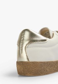 Weiße Ledersneaker mit einem metallic goldenen Akzent an der Ferse. Verfügt über eine strukturierte braune Gummisohle und ein geprägtes Logo an der Ferse.