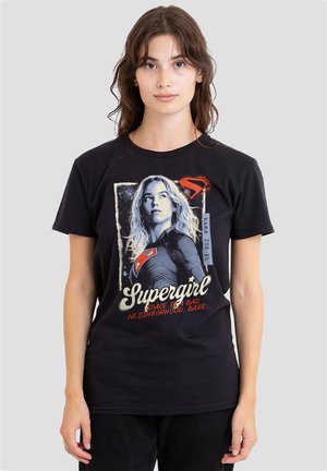 Young woman wearing a black Supergirl t-shirt showing a graphic of Supergirl with text "Space is a bad neighborhood, babe."