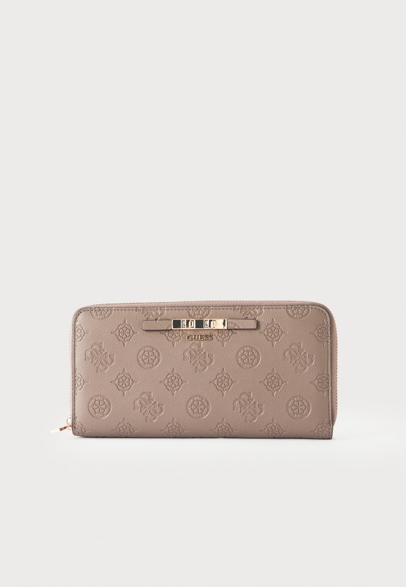 Portefeuille marron clair avec fermeture éclair autour, motifs floraux et logo embossés et un petit logo métallique doré Guess sur le devant.