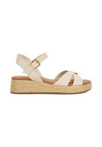 Beige wedge sandals with cross straps, adjustable ankle buckle, and woven jute platform. Smooth leather upper and cushioned footbed.