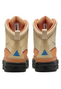 High-top sneakers with a cream and orange color scheme. Features textured leather and mesh upper, padded collar, and blue logo accents.