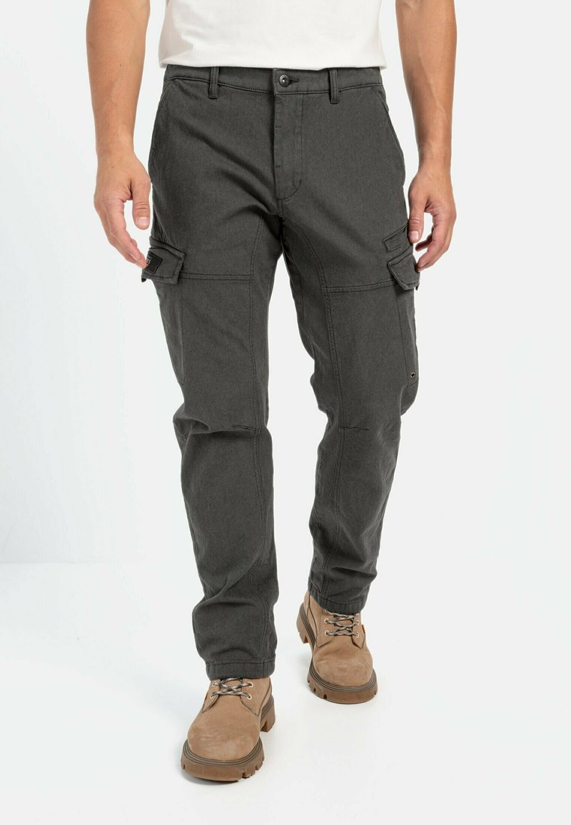 Dunkelgraue Cargo-Hose mit Seitentaschen, aus strapazierfähigem Stoff. Hat einen geraden Schnitt und einen Knopfverschluss, getragen mit beigefarbenen Stiefeln.