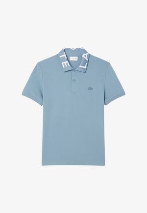 Lichtblauwe poloshirt met een zachte textuur, voorzien van een wit logo op de kraag en een klein logo op de borst. Korte mouwen.