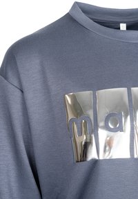 Niebiesko-szary shirt z błyszczącymi, srebrnymi prostokątnymi łatami, na których z przodu widnieje napis "mar", ukazujący strukturę i detale kołnierzyka.