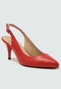 Pompe slingback en cuir rouge avec un bout pointu, une sangle à boucle dorée et un talon stiletto de hauteur intermédiaire sur un fond neutre.