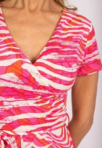 Różowa i pomarańczowa sukienka w wzory, zapinana na węzeł w pasie, z głębokim dekoltem w kształcie litery V, krótkimi rękawami oraz fakturowanym materiałem.