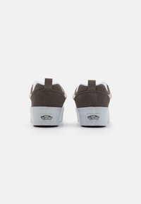 Brown suede low-top sneakers with white accents and grey rubber soles. Features a rear pull tab and "VANS OFF THE WALL" logo on the heel.