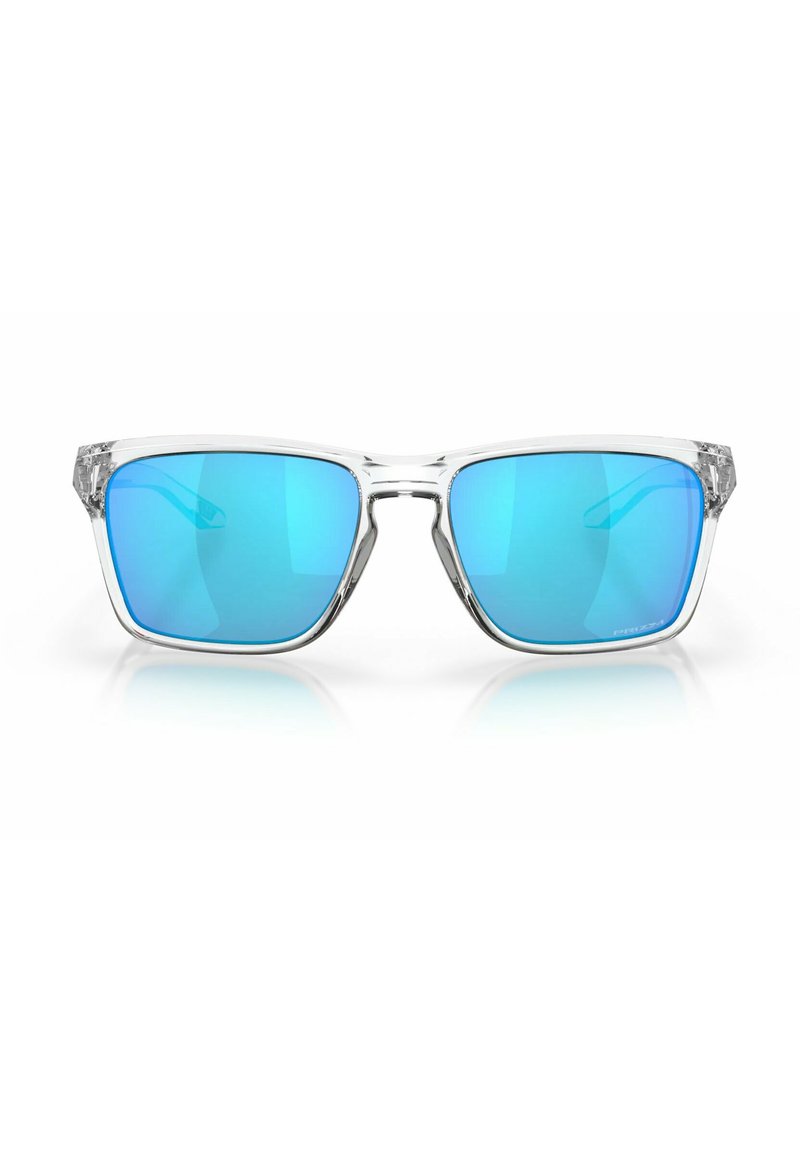 Gafas de sol de estructura clara con lentes azul degradado, forma rectangular y acentos metálicos en las patillas. Presentan una textura suave y brillante.