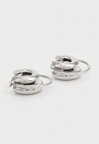 Silver hoop earrings featuring a spiral design with a smooth surface and rounded edges, showcasing a reflective metallic finish.
