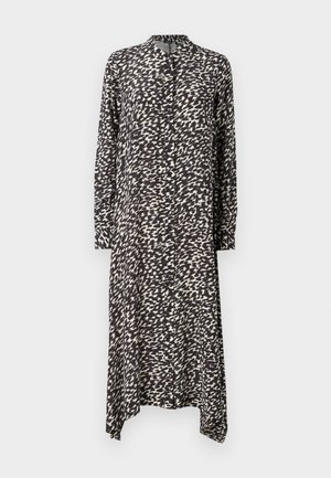 Pikk nööpidega kleit musta-valge abstraktse mustriga. Omab kraega, pikki varrukaid ja asümmeetrist lõhikut. Pehme, kerge kangas.