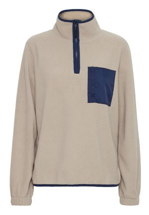 Lyse beige fleece pullover med en marineblå lynlåslomme på brystet, høj krave og elastiske manchetter. Blød tekstur og afslappet pasform.