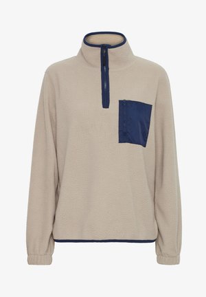 Lyse beige fleece pullover med en marineblå lynlåslomme på brystet, høj krave og elastiske manchetter. Blød tekstur og afslappet pasform.