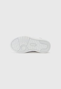 Semelle de sneaker blanche avec caoutchouc texturé pour une meilleure adhérence, comportant un détail de logo circulaire et un motif de semelle complexe pour une traction optimale.