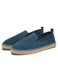 Espadrilles en daim bleu avec une semelle en jute tressé, présentant un design à enfiler et des détails cousus le long du bord.