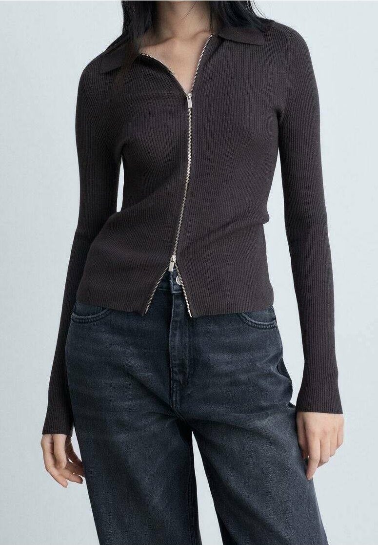 Pull zippé marron foncé à côtes avec col, manches longues et coupe légèrement courte, associé à un jean en denim foncé.