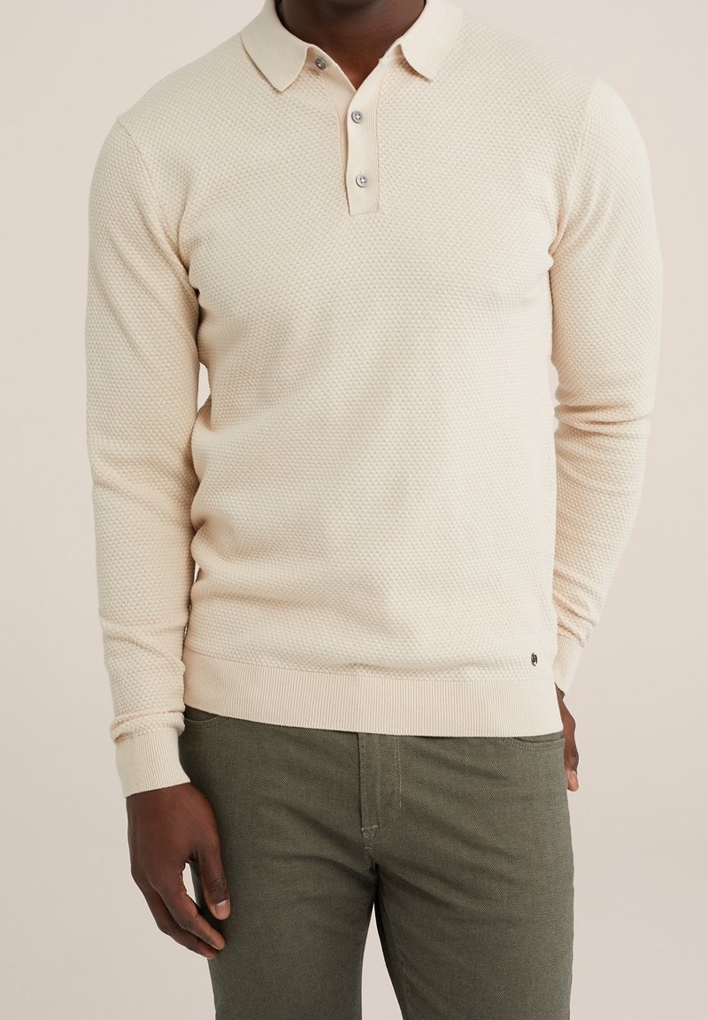 Light beige long-sleeve polo with a textured knit pattern, three-button placket, and ribbed cuffs and hem. It has a small logo detail.