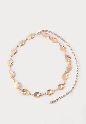 Ζώνη σε χρυσό τόνο με συνδεδεμένες παράτυπες οβάλ μεταλλικές πλάκες και ρυθμιζόμενο κούμπωμα αλυσίδας σε απλό φόντο.