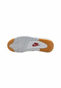 Suela de zapatilla Nike con una base de goma blanca, acentos naranjas y patrones de superficie texturizados. Logo de Nike rojo prominente cerca del talón.