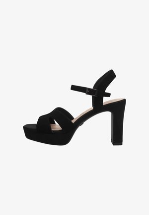 Black platform sandals featuring a closed toe, crisscross straps, adjustable ankle strap, and a high block heel. Made of soft suede material.