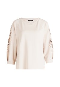 Sweatshirt beige clair à manches trois-quarts. Présente des embellissements floraux décoratifs sur les manches. Tissu doux, coupe décontractée, col rond.