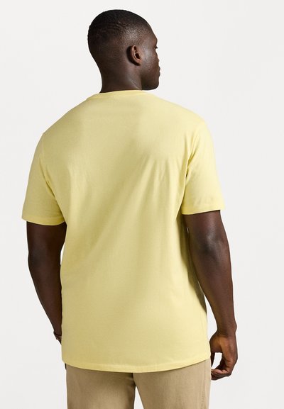 Short-sleeve yellow t-shirt made of cotton, featuring a standard crew neck and a relaxed fit, visible stitching along the hem and sleeves.