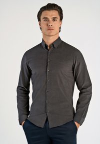 Donkergrijze langemouwen knoopshirt met een kraag, gestructureerde pasvorm en textuurstof. Voorzien van zwarte knopen aan de voorkant.