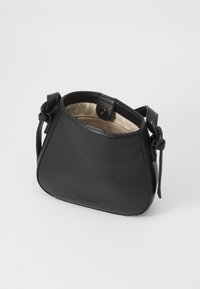 Borsa a tracolla nera in pelle con forma arrotondata, caratterizzata da una tracolla annodata e un interno foderato in beige. Chiusura a scatto, design minimalista.