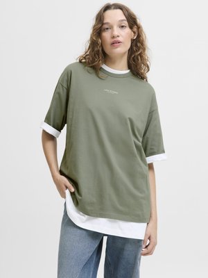 Olivenfarget oversized t-skjorte med hvit indre lag og mansjetter, laget av bomull, rund hals, og liten logo detalj på brystet.