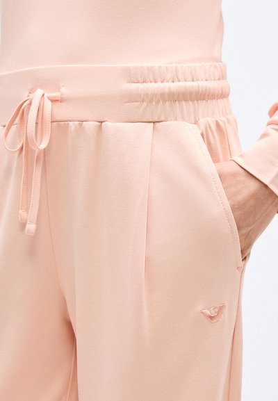 Ροζ απαλό παντελόνι με ελαστική μέση και κορδόνι, χέρι στην δεξιά τσέπη, διακριτικό κεντητό λογότυπο στον μηρό.