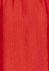 Roter Stoff mit einer glatten, leicht strukturierten Oberfläche. Leicht und fällt mühelos, in einer einheitlichen Farbe ohne Muster oder Akzente.