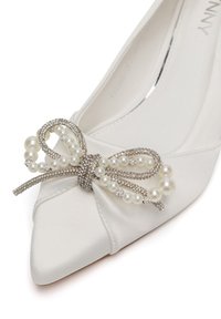 Valge satiiniga terava ninaga king, mille esiküljel on pärlite ja kivikestega kaunistatud lips.