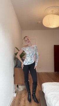 Kūno prigludusi, vienakrumplė palaidinė pastelinių abstrakčių raštų, derinama su juodomis pėdkelnėmis ir juodais aukštakulniais batais iki kelių. Medinis grindų fono akcentas.