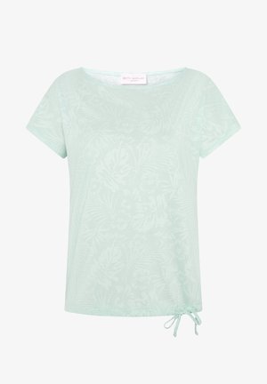 Lysegrøn top med korte ærmer, subtilt blomsterprint og lille bindedetalje nederst til højre.